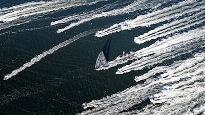 Comanche is escorted by spectator boats as it crosses the finish line in Hobart to win the Sydney to Hobart yacht race. AP
