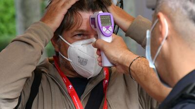 A festivalgoer undergoes a body temperature scan outside the festival's palace on the opening day of the 77th Venice Film Festival. AFP