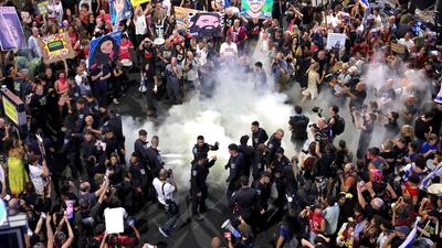 Israeli police extinguish a fire set by demonstrators during an anti-government protest calling for action to secure the release of Israeli hostages. AFP