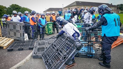 Mock protesters build a barricade in front of police officers. AFP