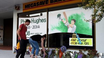 People lay flowers at a tribute to Philipp Hughes in his hometown of Macksville, Australia. Dan Himbrechts / EPA