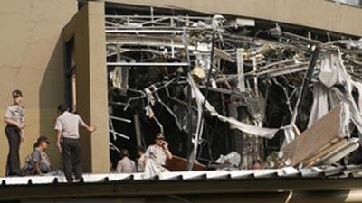 Police officers inspect the damage after an explosion went off at the Marriott hotel in Jakarta, Indonesia, Friday, July 17 2009. Bombs exploded at the Ritz-Carlton and Marriott hotel.