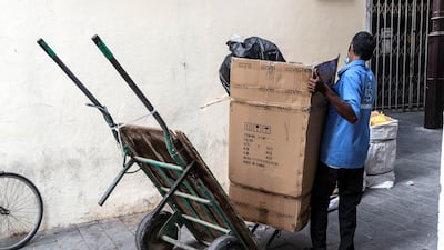 A porter loads a big box on a cart in Deira on June 22.