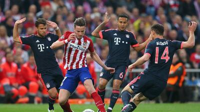 Saul Niguez of Atletico Madrid takes on Juan Bernat, Thiago Alcantara and Xabi Alonso of Bayern Munich during the Uefa Champions League semi-final first leg match between Atletico Madrid and FC Bayern Munich at Vincente Calderon on April 27, 2016 in Madrid, Spain. (Photo by Alexander Hassenstein/Bongarts/Getty Images)