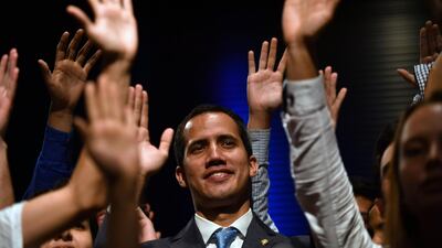 Venezuela's National Assembly head and self-proclaimed acting president Juan Guaido raises his hands surrounded by students after speaking at the Metropolitan University in Caracas. AFP