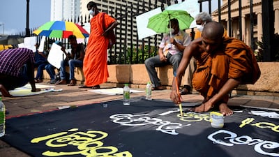 A Buddhist monk prepares a placard at a demonstration against the economic crisis. AFP