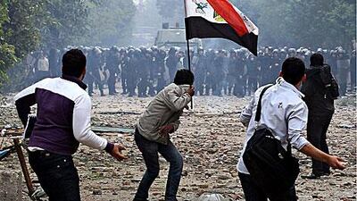 Youths confront security forces in Cairo yesterday. At least four people were killed and nearly 1,000 injured in the confrontations as protesters called for an end to military rule, but it was unclear if security forces had caused the deaths.