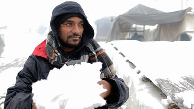 A migrant carries snow at the Lipa camp. AP Photo