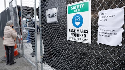 A woman talks to a worker behind a locked gate at the 24-hour coronavirus mass vaccination site at the Brooklyn Army Terminal in Brooklyn, New York. Reuters