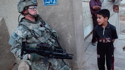 An Iraqi boy encounters a US soldier on ground patrol in the Baladiyat neighbourhood of Baghdad in 2008
