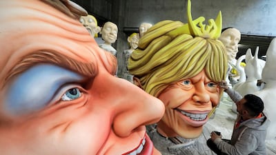 A worker puts the final touches on giant figures of French President Emmanuel Macron and his wife Brigitte Macron during preparations for the carnival parade in Nice, France. Reuters