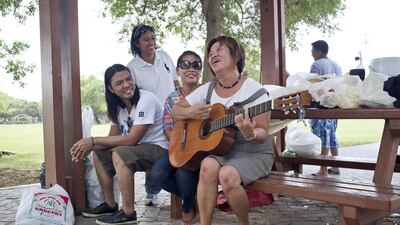 Eva Borrios plays the guitar for her friends as they spend their Eid Friday at Safa Park enjoying the lapse in August heat by having a picnic with friends and co-workers. Antonie Roberston / The National