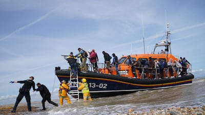 British immigration enforcement officers help migrants from a lifeboat in Dungeness, Kent, on September 13. PA