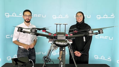 IoT systems engineer Ahmed Borik and Nabra Al Busaidi, sustainability and community manager, at the press launch of Cafu's project. Pawan Singh / The National