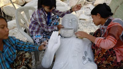 Workers polish a Buddha statue at a marble mine at Zagyin village. Soe Zeya Tun / Reuters