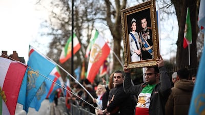 A protester holds up a portrait of Mohammad Reza Pahlavi, the last Shah of Iran. AFP