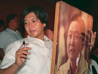 Then-opposition senatorial candidate Ferdinand Marcos Jr autographing a portrait of his late father, the ousted dictator Ferdinand Marcos, during a campaign rally in Manila ahead of the 1995 elections. AFP