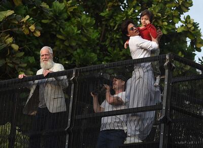 American TV host David Letterman can be seen peering over the fence as Bollywood actor Shah Rukh Khan greets fans outside his Mumbai, India home on Eid Al Fitr, while holding his son, AbRam. A camera crew can be seen through the fence. AFP