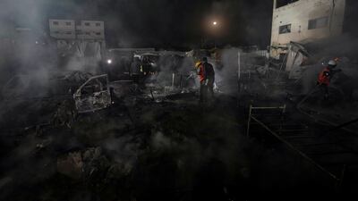 Palestinian firefighters extinguish a blaze caused by an Israeli strike on Al Aqsa Hospital in Deir Al Balah. Four people have been killed and more are feared dead. AP