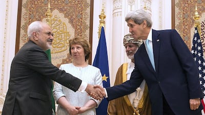US secretary of state John Kerry, right, and Iranian foreign minister Javad Zarif, left, shake hands as Omani minister responsible for foreign affairs Yussef bin Alawi, secod right, and former EU top diplomat Catherine Ashton look on during their meeting in Muscat on November 9, 2014. Nicholas Kamm/AFP Photo