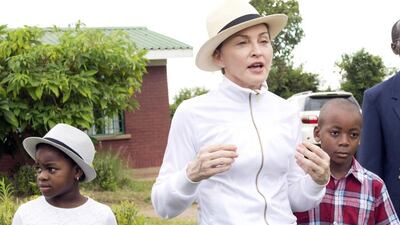 Madonna tours the Mphandura orphanage near the Malawian capital with her two adopted Malawian children, David Banda (right) and Mercy James (left) on February 7, 2017. Thoko Chikondi, File / AP Photo