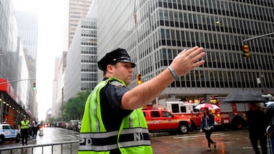 A policeman gestures near fire trucks. AFP