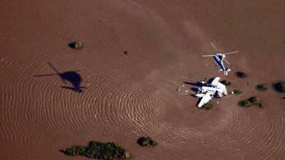 A handout picture provided by the Uruguayan Air Force shows a helicopter flying over an Argentinian aircraft which crashed into the River Plate, close to Colonia, Uruguay. The Argentinian Government confirmed that five people died and four were injured after the crash. Uruguayan Air Force/ EPA