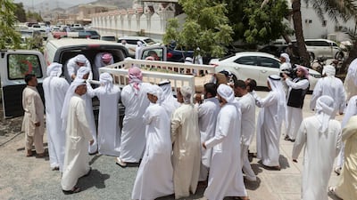 Friends and family pay their respects as Hayayei's body is lowered into a grave. Antonie Robertson / The National