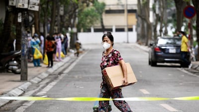 A woman walks inside an isolated area on Truc Bach street in Hanoi. AFP