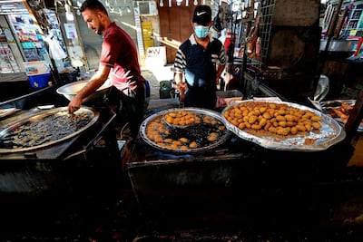 Street venders make traditional sweets at old Basra market, Iraq, Wednesday, Oct. 21, 2020. Iraq is in the throes of an unprecedented liquidity crisis, as the cash-strapped state wrestles to pay public sector salaries and import essential goods while oil prices remain dangerously low. AP