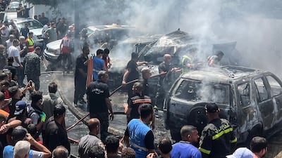 First responders and residents gather at the site of an Israeli air strike that hit a car in Sidon. AFP