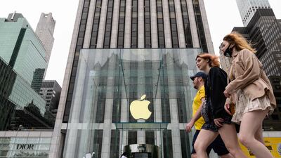 People walk past an Apple retail store in New York City. The tech company is delaying the return of staff to the office as Covid-19 variants spread across the world. AFP