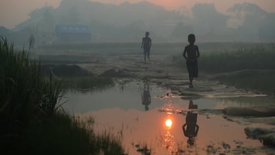 Rohingya refugees walk through Palong Khali refugee camp at sunrise, near Cox's Bazar, Bangladesh. Hannah McKay / Reuters