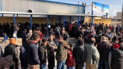 People queue to buy bread in the city of Aleppo in Syria, where a shortage of basic goods has created demand for products smuggled from Lebanon. Anadolu Agency via Getty Images