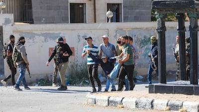 An injured man is carried away during clashes in an area between the villages of Mazraa and Walga, near the predominantly Druze city of Sweida. AFP