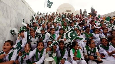 Attendees wave Pakistan's national flag while singing national songs at a ceremony to celebrate the country's 70th Independence Day at the mausoleum of Muhammad Ali Jinnah in Karachi, Pakistan August 14, 2017. REUTERS/Akhtar Soomro