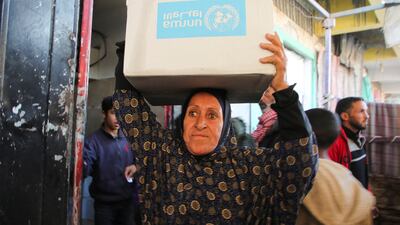 A Palestinian woman carries a box of aid provided by UNRWA, in Khan Younis, in the southern Gaza Strip, in January. Reuters