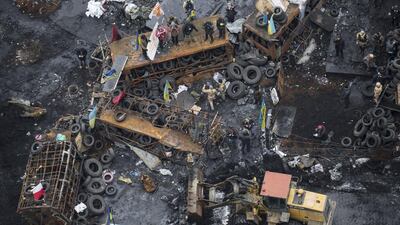 A bulldozer removes barricades on February 16, 2014, at the site of recent clashes with riot police in the Ukrainian capital of Kiev. Scores of Ukrainian anti-government protesters ended a two-month-old occupation of city hall in Kiev on Sunday to meet a government amnesty offer. Vlad Sodel / Reuters
