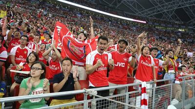 Singaporean Arsenal fans cheer for their team before the Asia Trophy final on Saturday against Everton at the National Stadium in the city-state. Lionel Ng / Getty Images