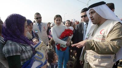Rashid Al Mansouri, consul general of the UAE to Irbil, meets Syrian-Kurdish refugees as aid is distributed by Emirates Red Crescent at the Quru Gusik refugee camp in the Kurdish region of northern Iraq. Safin Hamed / AFP