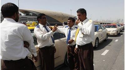 Taxi drivers, from left, Sham K, Noor Khan, Salim Khan and Naziz Khan wait for passengers near Ibn Battuta Metro Station.