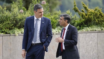 Spain's President Pedro Sanchez, left, and Mr Sunak walk to the podium for a photograph with heads of states and country representatives. AFP
