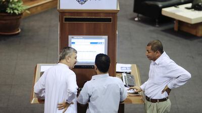 Traders work on the floor at the Dubai Financial Market at Dubai World Trade Centre. Sarah Dea / The National