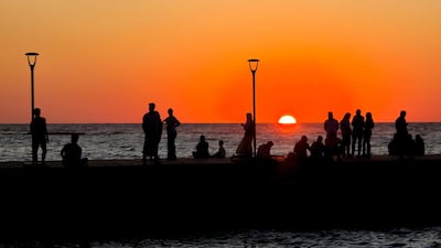 People gather along the corniche as the sun sets in the Libyan capital Tripoli. AFP