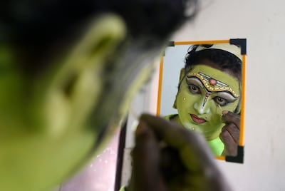 A kathakali performer paints his face before performing for Onam festivities. AFP
