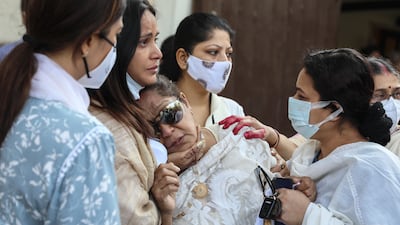 Chitrani Lahiri, wife Bappi Lahiri, being consoled by friends and family. EPA