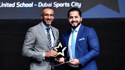 Mohammad Abusenenh receives his prize from Dino Varkey, chief executive of Gems Education. Courtesy Gems Education