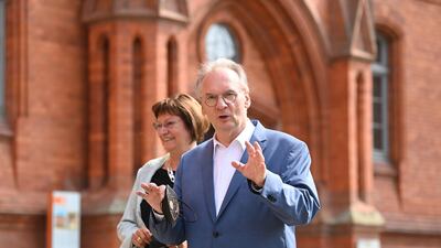 The governor of Saxony- Anhalt, Reiner Haseloff, right, of Chancellor Angela Merkel's Christian Democratic Union party, CDU, and his wife Gabriele Haseloff, arrive at the polling station during the state election in Saxony-Anhalt in Wittenberg, Germany, on Sunday, June 6, 2021. AP