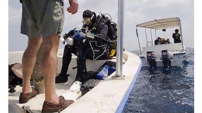 Bill Leeman checks his gear before entering the water.