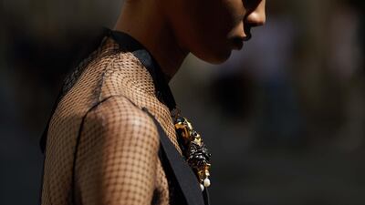 Cocktail suit top and embroidered skirt; black mesh T-shirt; embellished tights; and heels, all from Dior Haute Couture.